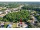 Aerial view showing the home in relation to surrounding neighborhood and wooded areas at 10228 Beechcraft St, New Port Richey, FL 34654
