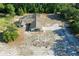 Aerial view of a house with a screened pool, driveway, and treed landscaping on a spacious lot at 10228 Beechcraft St, New Port Richey, FL 34654