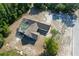 Aerial view of a house with a screened pool, driveway, and treed landscaping on a spacious lot at 10228 Beechcraft St, New Port Richey, FL 34654