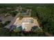 An aerial view shows a home with a pool and treed landscaping on a lot surrounded by a neighborhood at 10228 Beechcraft St, New Port Richey, FL 34654