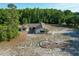 Aerial view of a house with a screened pool, driveway, and treed landscaping on a spacious lot at 10228 Beechcraft St, New Port Richey, FL 34654