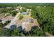 Aerial view shows a home with a pool and treed landscaping on a lot surrounded by a neighborhood at 10228 Beechcraft St, New Port Richey, FL 34654