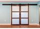 Modern wood-framed sliding barn doors adding character and privacy to a room with light blue walls at 10228 Beechcraft St, New Port Richey, FL 34654