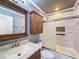 Cozy bathroom with granite countertops, wood cabinets, and tiled shower with glass doors at 10228 Beechcraft St, New Port Richey, FL 34654