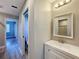 Bathroom featuring a white vanity with chrome fixtures and a mirror above, adjacent to the toilet in the bathroom at 10228 Beechcraft St, New Port Richey, FL 34654