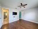 Spacious bedroom showcasing hardwood floors, a ceiling fan, and two doorways, providing ample living space at 10228 Beechcraft St, New Port Richey, FL 34654