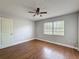Bright bedroom with hardwood floors, ceiling fan, and a window with natural light, creating a comfortable living space at 10228 Beechcraft St, New Port Richey, FL 34654