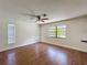 Bedroom featuring hardwood floors, a ceiling fan, and two windows with blinds at 10228 Beechcraft St, New Port Richey, FL 34654