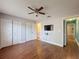 Bedroom featuring hardwood floors, a ceiling fan, two closets, and two doorways, offering practical storage and access at 10228 Beechcraft St, New Port Richey, FL 34654