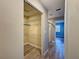 Hallway with wood-look flooring, leading to a shower and bedroom, with an open closet showing wire shelving at 10228 Beechcraft St, New Port Richey, FL 34654