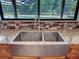 Close up of a stainless steel sink with a view of the pool from the kitchen window at 10228 Beechcraft St, New Port Richey, FL 34654