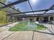 Backyard view of the in-ground pool with a screened enclosure, patio, and direct access to the home at 10228 Beechcraft St, New Port Richey, FL 34654
