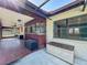 Outdoor patio with tiled floors and wooden features connecting to the screened-in pool area, providing a cozy transition space at 10228 Beechcraft St, New Port Richey, FL 34654