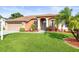 Charming single Gathering home featuring a well-manicured lawn, arched entryway, and attached two-car garage at 12040 Penzance Ln, New Port Richey, FL 34654