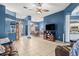 Spacious living room with blue walls, tile flooring, open concept layout, and large windows at 12040 Penzance Ln, New Port Richey, FL 34654