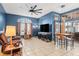 Open-concept living area with a large television, entertainment center, and comfortable seating, bathed in natural light at 12040 Penzance Ln, New Port Richey, FL 34654