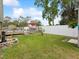 Spacious backyard with wooden deck, pool, red umbrella, and stone fire pit at 13052 Drysdale St, Spring Hill, FL 34609