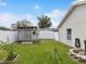 Well-maintained backyard featuring a garden shed, white fence, and lush green grass at 13052 Drysdale St, Spring Hill, FL 34609