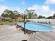 Well-maintained above-ground pool with wood deck, outdoor seating, manicured garden and landscaping, shed and white fence at 13052 Drysdale St, Spring Hill, FL 34609