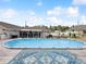 Large above-ground pool surrounded by a wooden deck, lounge chairs, and a partially-covered patio, under a blue sky at 13052 Drysdale St, Spring Hill, FL 34609