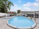 Inviting above-ground pool with wooden deck, lounge chairs, and a backyard with a white fence, set under a sunny sky at 13052 Drysdale St, Spring Hill, FL 34609
