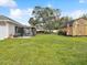 Spacious backyard featuring a garden shed, mature trees, and chain link fence at 13052 Drysdale St, Spring Hill, FL 34609