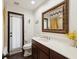 Well-lit bathroom features a wooden vanity, framed mirror, and tub shower combo with decorative tile at 13052 Drysdale St, Spring Hill, FL 34609
