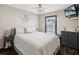 Cozy bedroom with a queen bed, modern ceiling fan, dark trim and wood-look floors at 13052 Drysdale St, Spring Hill, FL 34609