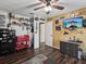 This bonus room features wood-look flooring, a ceiling fan, wood accent walls and various decorations and shelving at 13052 Drysdale St, Spring Hill, FL 34609