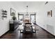 Bright dining room featuring dark wood floors, a long table with benches and large windows with light colored curtains at 13052 Drysdale St, Spring Hill, FL 34609