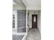 Inviting home entrance with a tiled porch, screened entryway, and a stylish front door at 13052 Drysdale St, Spring Hill, FL 34609