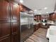 Gourmet kitchen with stainless steel fridge and ovens, ample wood cabinets at 13052 Drysdale St, Spring Hill, FL 34609