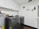 Laundry area with modern washer and dryer set, white cabinets and wall decor at 13052 Drysdale St, Spring Hill, FL 34609