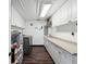 Well-lit laundry room with white cabinets, modern appliances, and wood-look flooring at 13052 Drysdale St, Spring Hill, FL 34609