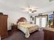 Bright main bedroom featuring wood furniture, ceiling fan and access to the pool deck at 13052 Drysdale St, Spring Hill, FL 34609