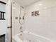 Bright bathroom features a white tub with shower combo and decorative tile accents at 13052 Drysdale St, Spring Hill, FL 34609