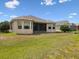 Backyard view showcases the home's exterior and spacious green lawn at 13618 Niti Dr, Hudson, FL 34669