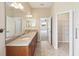 A spacious bathroom featuring double sinks, granite counters, large mirror and acces to closet at 13618 Niti Dr, Hudson, FL 34669