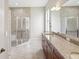 A spacious bathroom featuring double sinks, granite counters, large mirror and glass enclosed shower at 13618 Niti Dr, Hudson, FL 34669