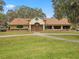 Exterior shot of the Meadow Oaks Golf & Country Club clubhouse featuring manicured lawn and landscaping at 13618 Niti Dr, Hudson, FL 34669