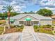 Community center with a well-manicured landscape, palm trees, and visible accessibility parking at 13618 Niti Dr, Hudson, FL 34669