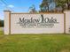 Community entrance sign displaying 'Meadow Oaks Golf Course Community,' welcoming visitors to the neighborhood at 13618 Niti Dr, Hudson, FL 34669