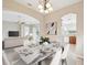 Open-concept dining area with marble-top table, modern chandelier, and seamless flow to the living spaces at 13618 Niti Dr, Hudson, FL 34669
