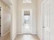 Bright foyer with tile flooring, white trim, and an inviting front door at 13618 Niti Dr, Hudson, FL 34669