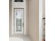 Close-up of a classic white front door with decorative glass insert at 13618 Niti Dr, Hudson, FL 34669