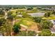 Scenic aerial of the golf course featuring lush greenery, mature trees, and a tranquil pond at 13618 Niti Dr, Hudson, FL 34669