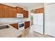 Well-lit kitchen featuring wood cabinetry, granite countertops, and modern appliances at 13618 Niti Dr, Hudson, FL 34669