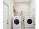 Efficient laundry room including a washer, a dryer, and storage shelving at 13618 Niti Dr, Hudson, FL 34669