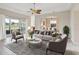 Bright living room featuring neutral tones, stylish seating, and views of the outdoor landscape at 13618 Niti Dr, Hudson, FL 34669