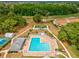 Aerial view of a community pool with lounge chairs, surrounded by mature trees and landscaping at 13618 Niti Dr, Hudson, FL 34669
